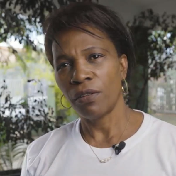 A Lú em uma entrevista, em um ambiente ao ar livre.